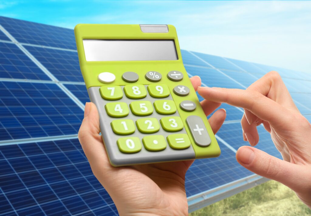 operating a calculator in front of solar panels